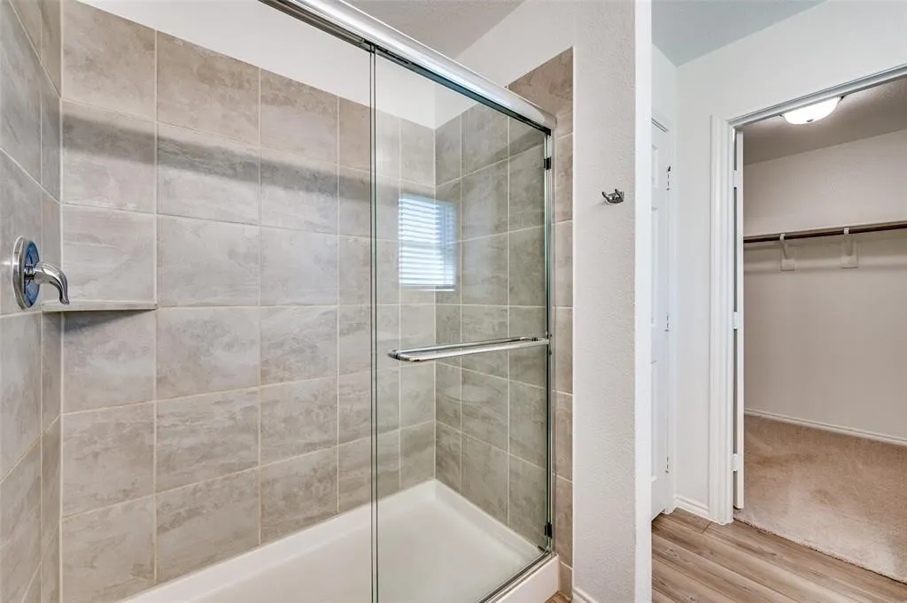 Glass-enclosed shower with subway-tiled walls and an integrated shower niche