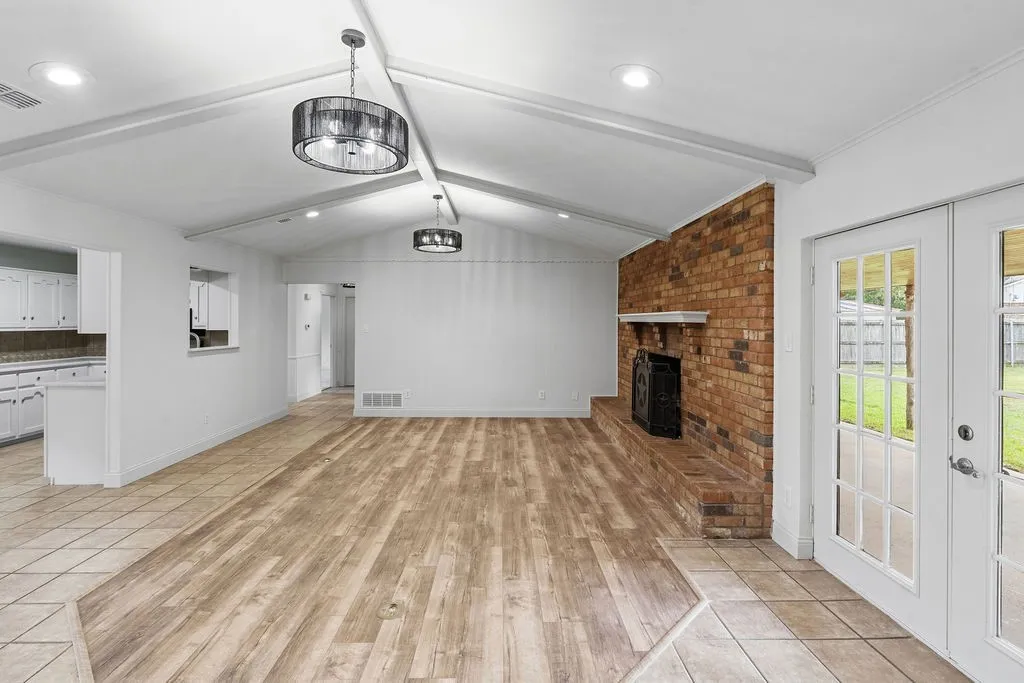 Living room with view of french doors to covered back porch, kitchen, and entryway
