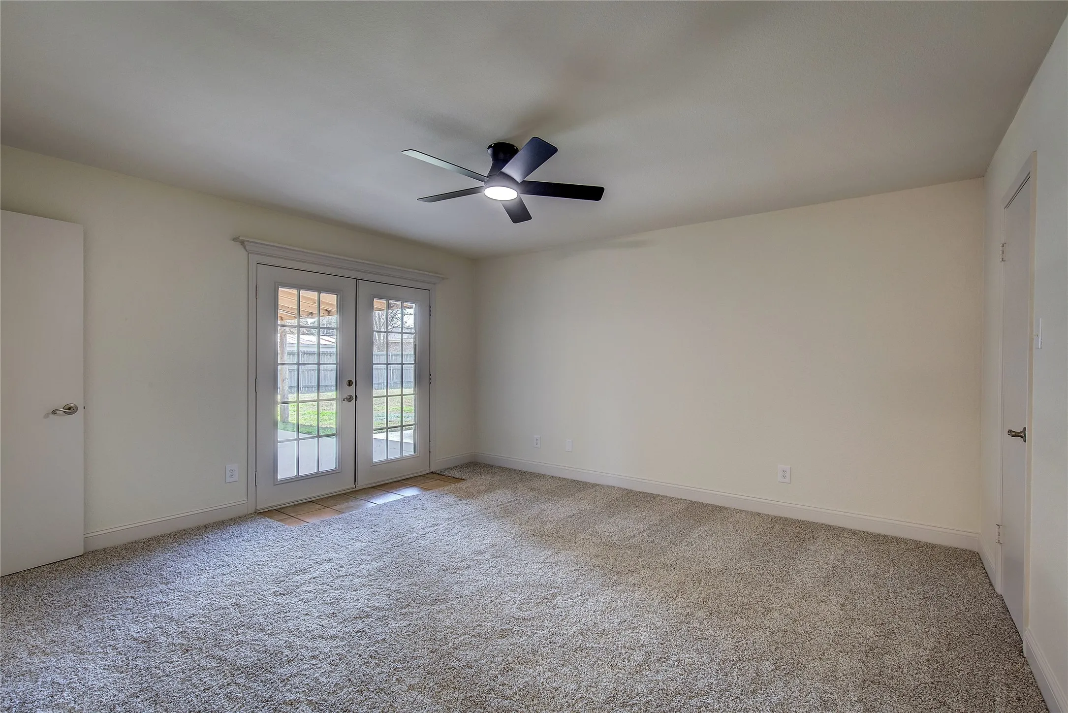 Primary bedroom has new carpet and paint, remodeled ensuite bath, two WICs plus linen closet, double doors to covered back porch.