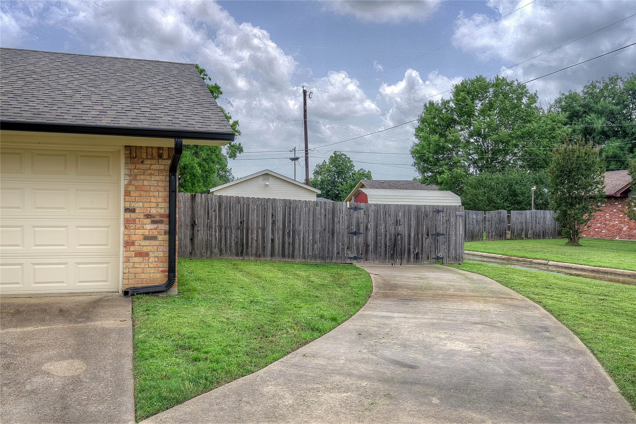 Front yard has dedicated concrete drive through back yard gates that lead to the workshop.