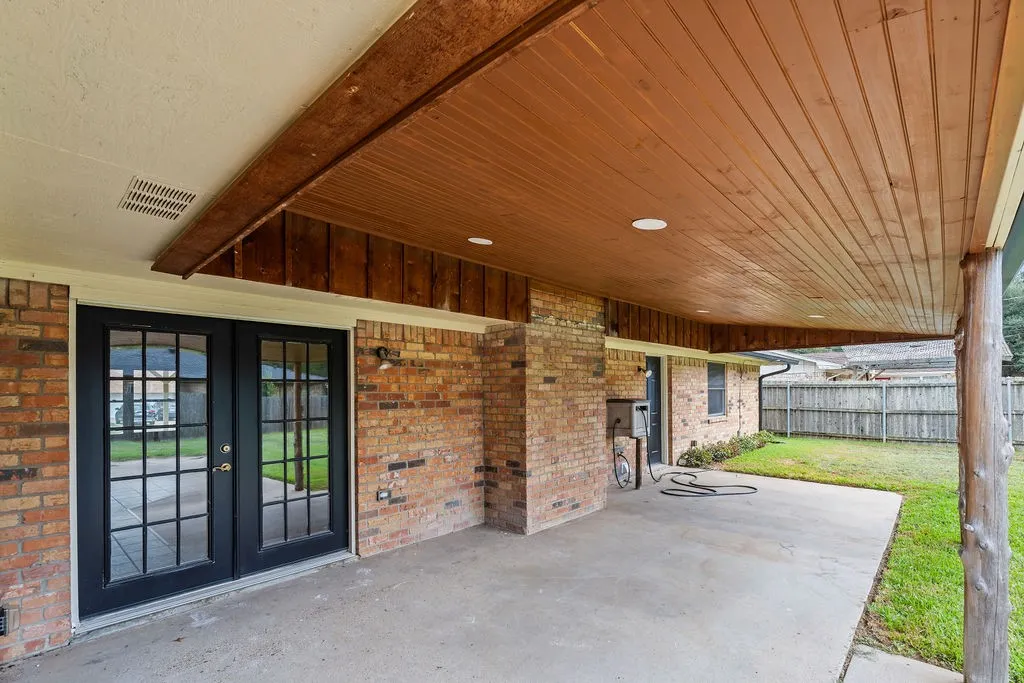 Covered back porch with gorgeous wood ceiling; french doors to living room and entry to laundry/mud room.