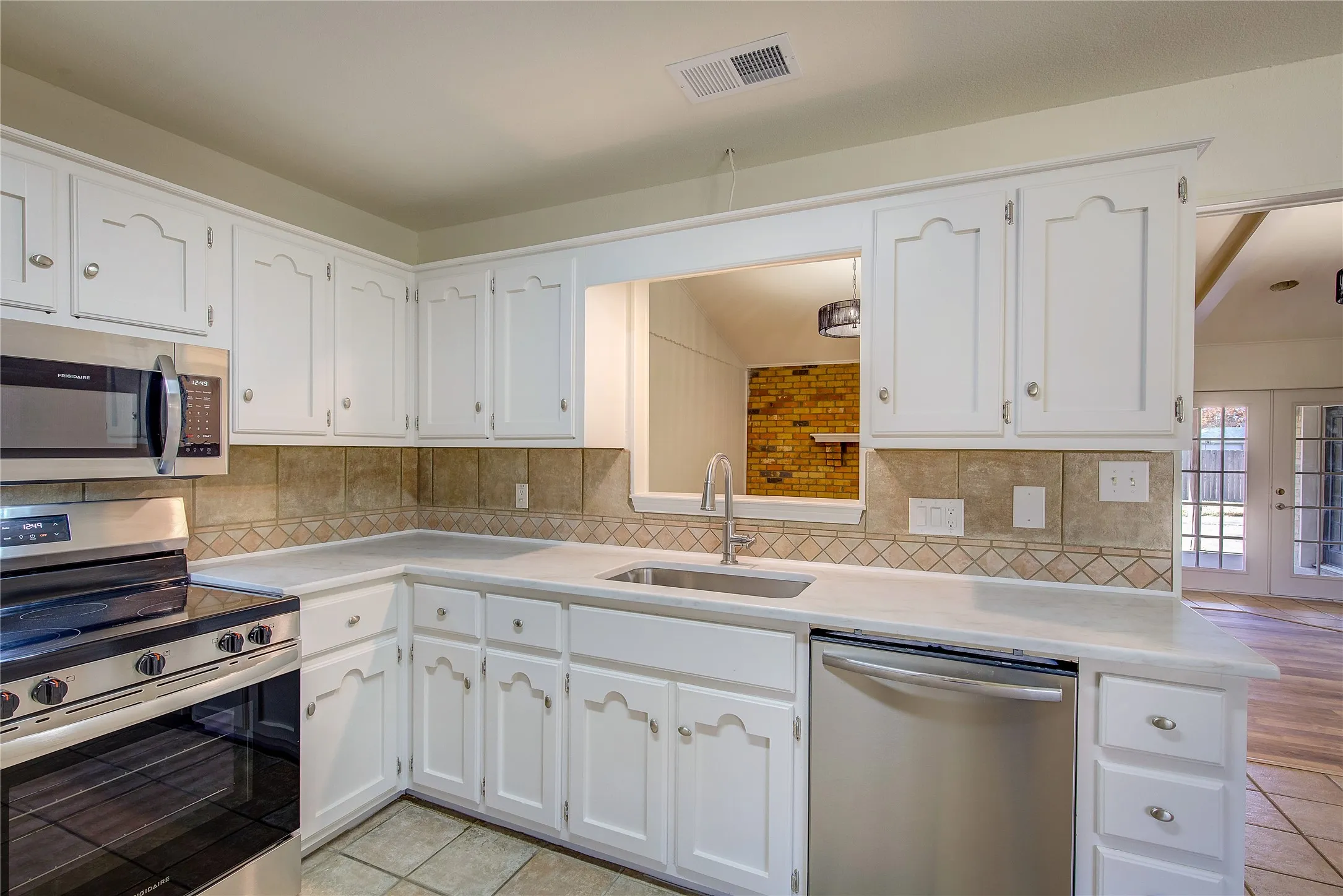 Kitchen has lots of cabinet storage, plus pass through to living room.
