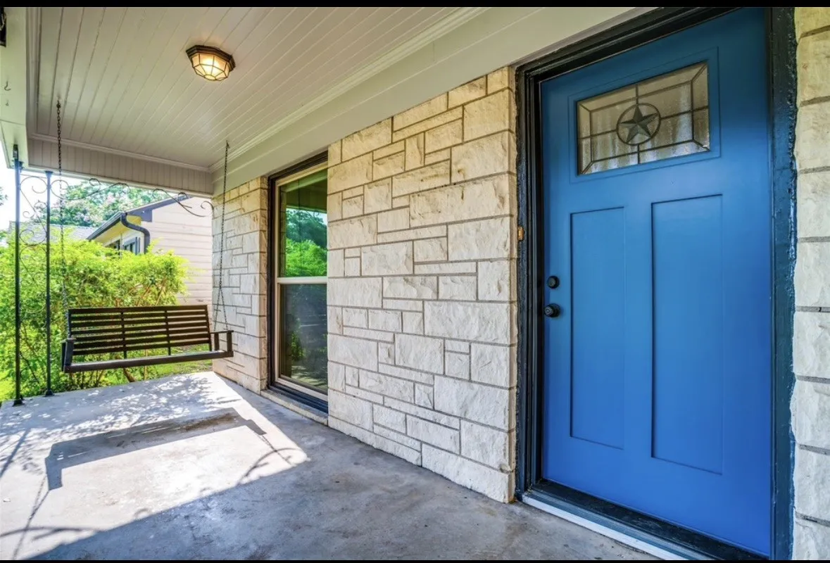 Stone exterior with a vibrant blue entry door featuring a decorative glass insert