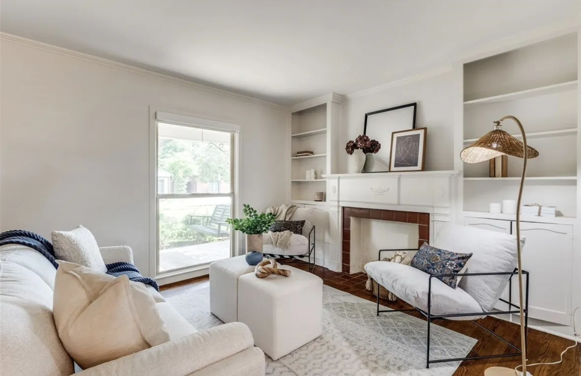 Fireplace with a mantel, built-in shelving, wood-finish flooring, and crown molding