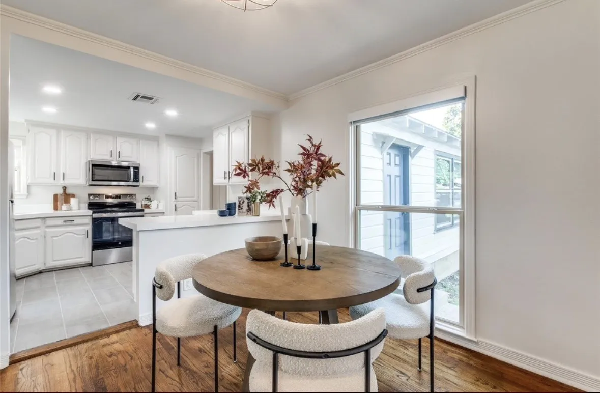 Wood-finish flooring, white walls, and a large window with white trim
