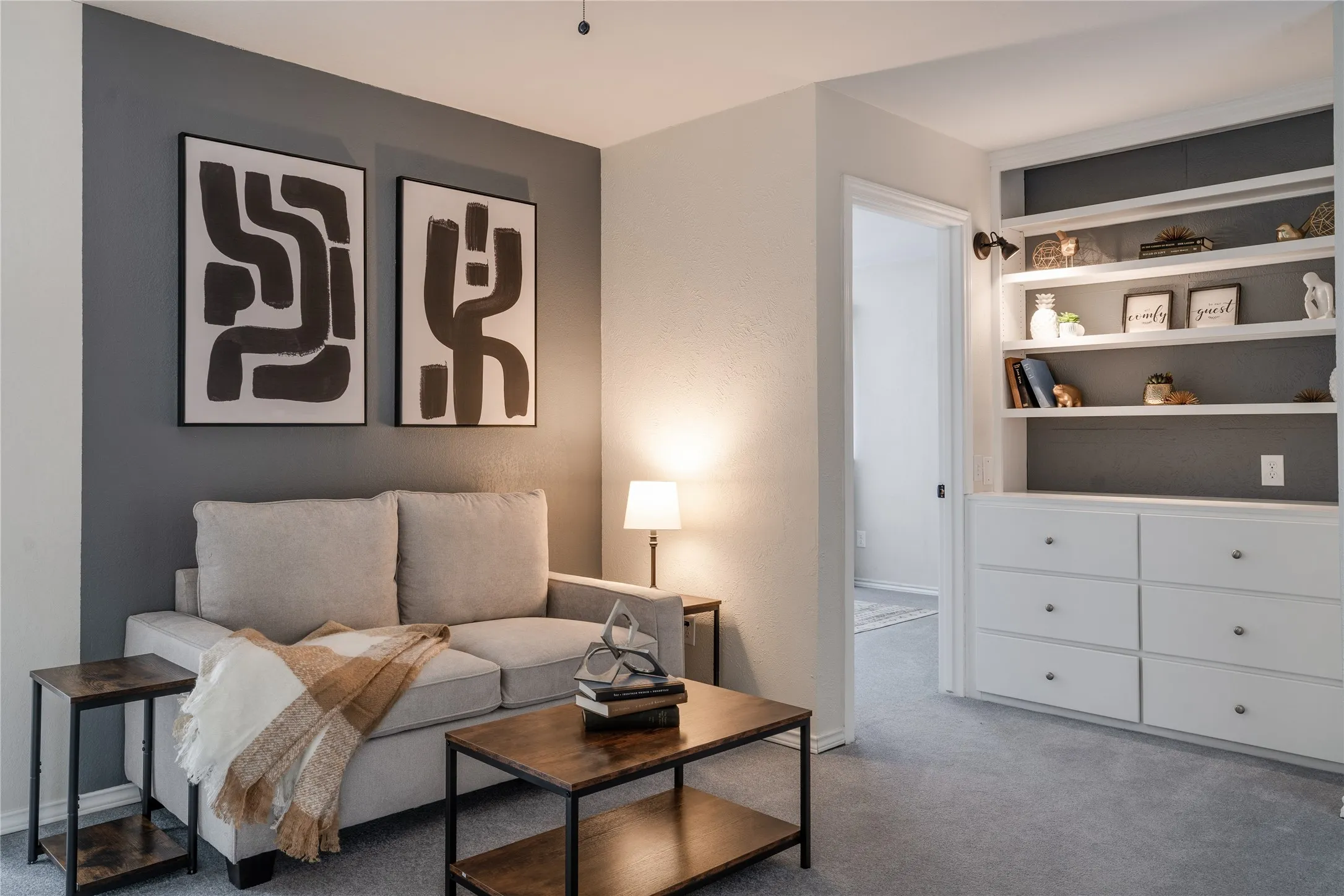 Integrated built-in shelving with lower storage drawers, recessed lighting, and a textured accent wall