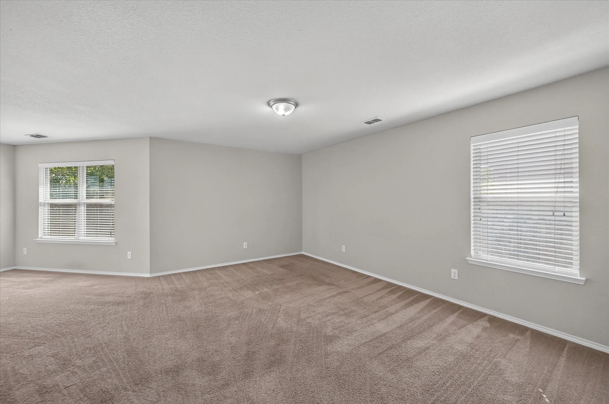 Neutral wall color throughout, recessed window, and flush-mount ceiling light