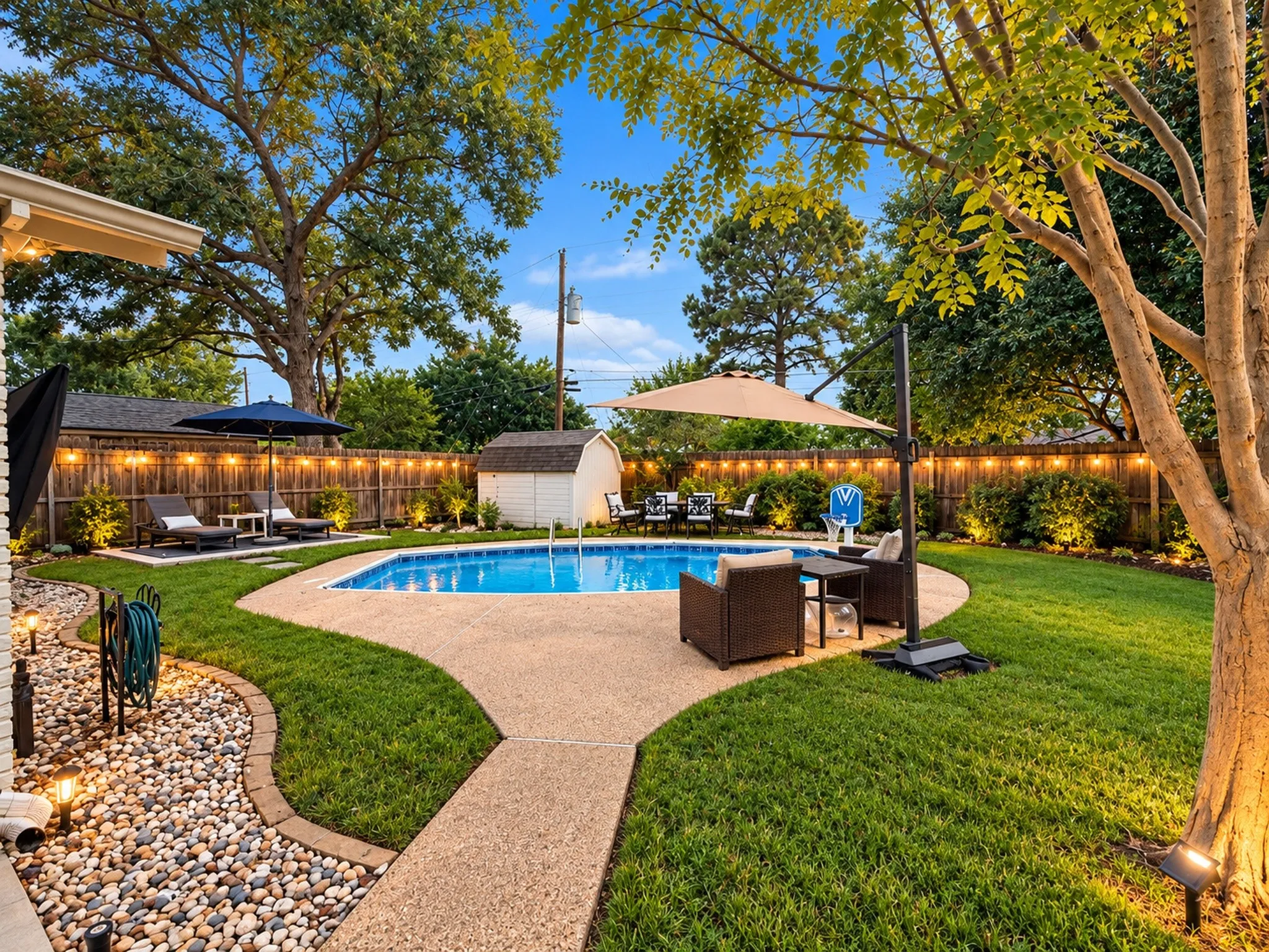 Private backyard featuring a swimming pool, concrete patio, a storage shed, and mature trees