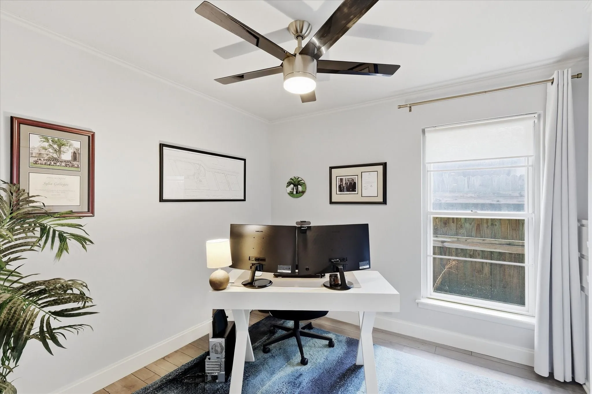 Recessed lighting, a ceiling fan with integrated lighting, and a window with roller shades