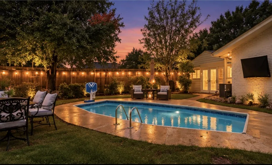 Private backyard oasis featuring an in-ground swimming pool, extensive paving, mature landscaping, and a privacy fence