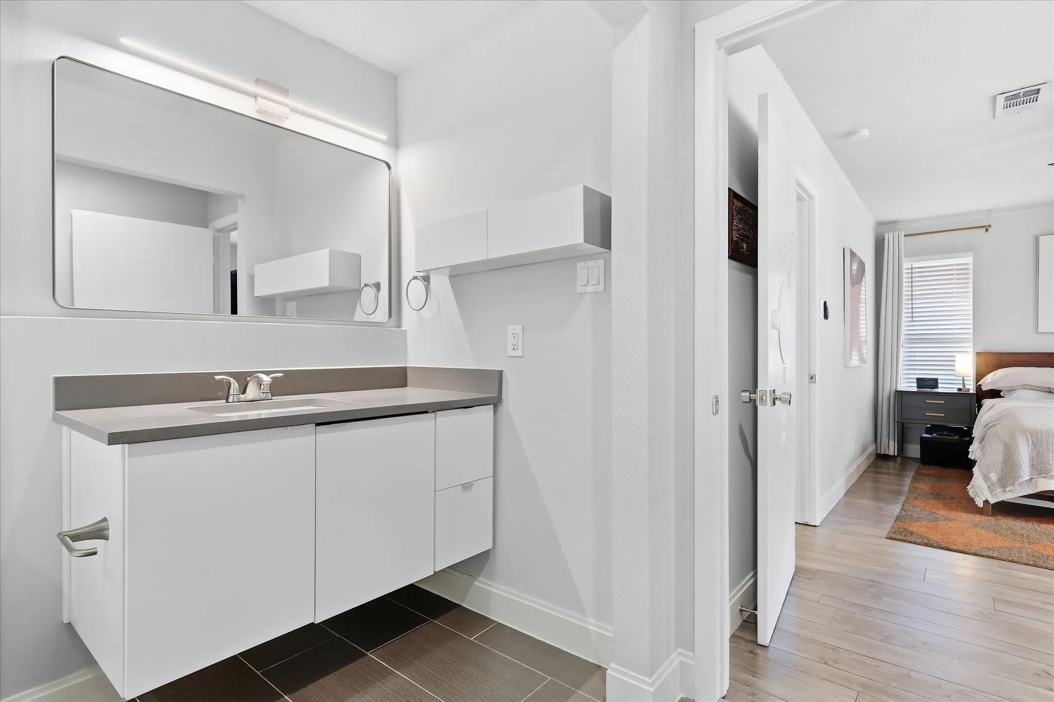 Primary Floating vanity with a light gray quartz countertop, rectangular undermount sink, and polished chrome faucet