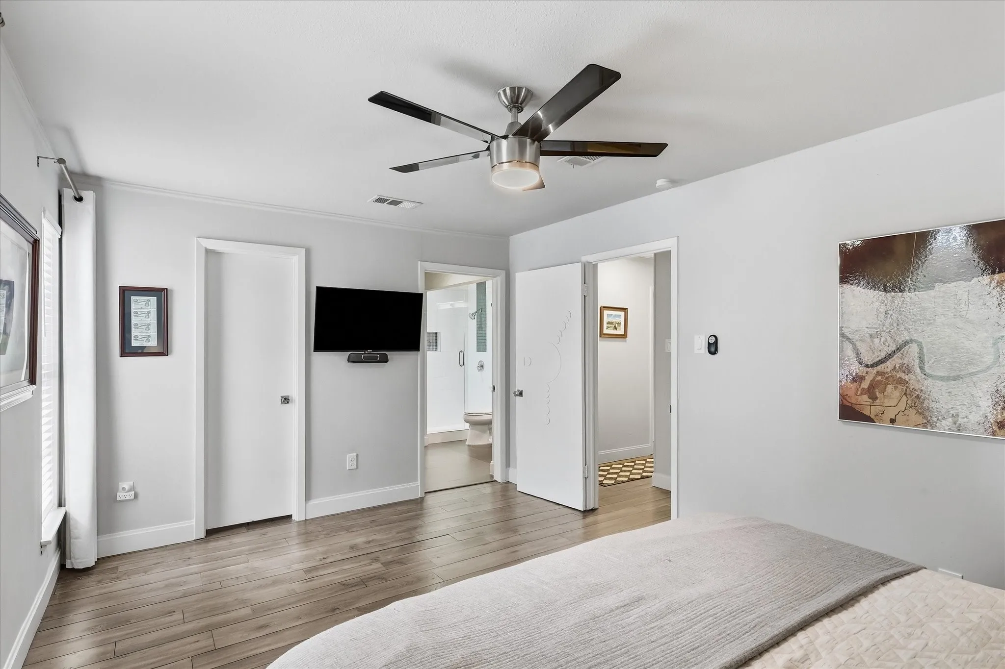 Faux wood-finish flooring with a ceiling fan featuring a light fixture