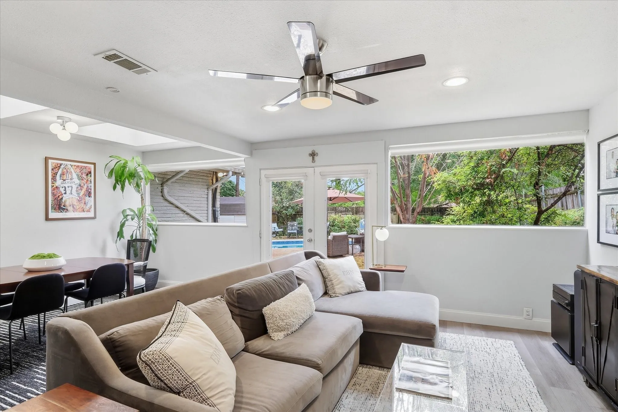 Recessed lighting with a modern ceiling fan, wood-finish flooring, and expansive windows