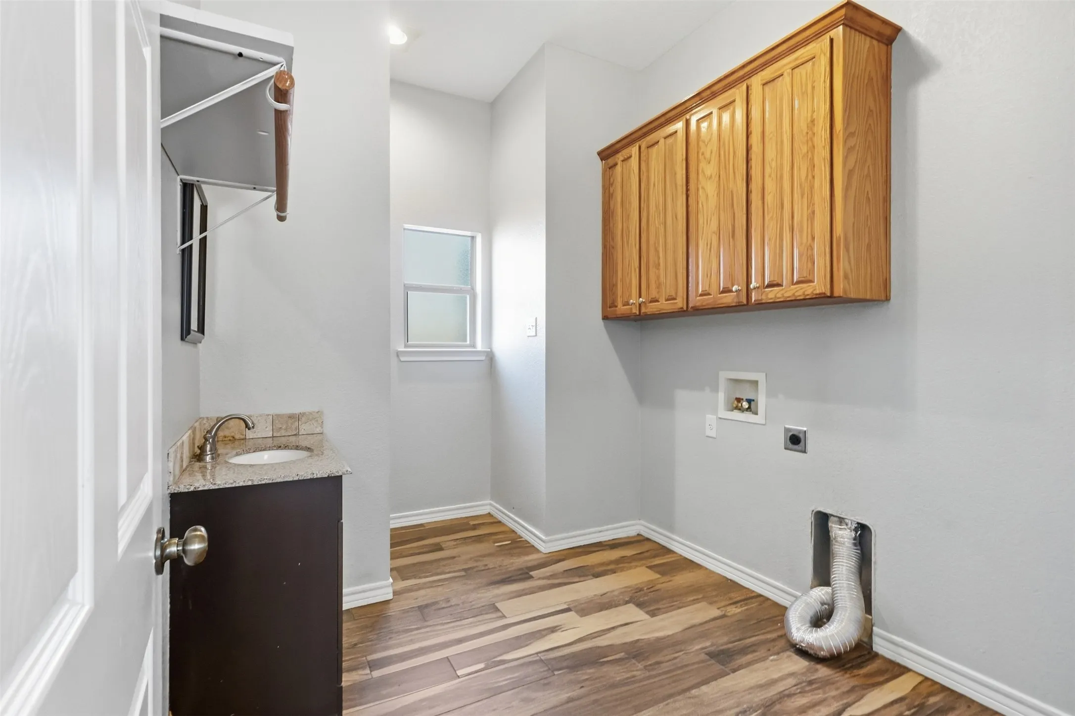 Half bath (toilet and sink) tucked in the laundry space