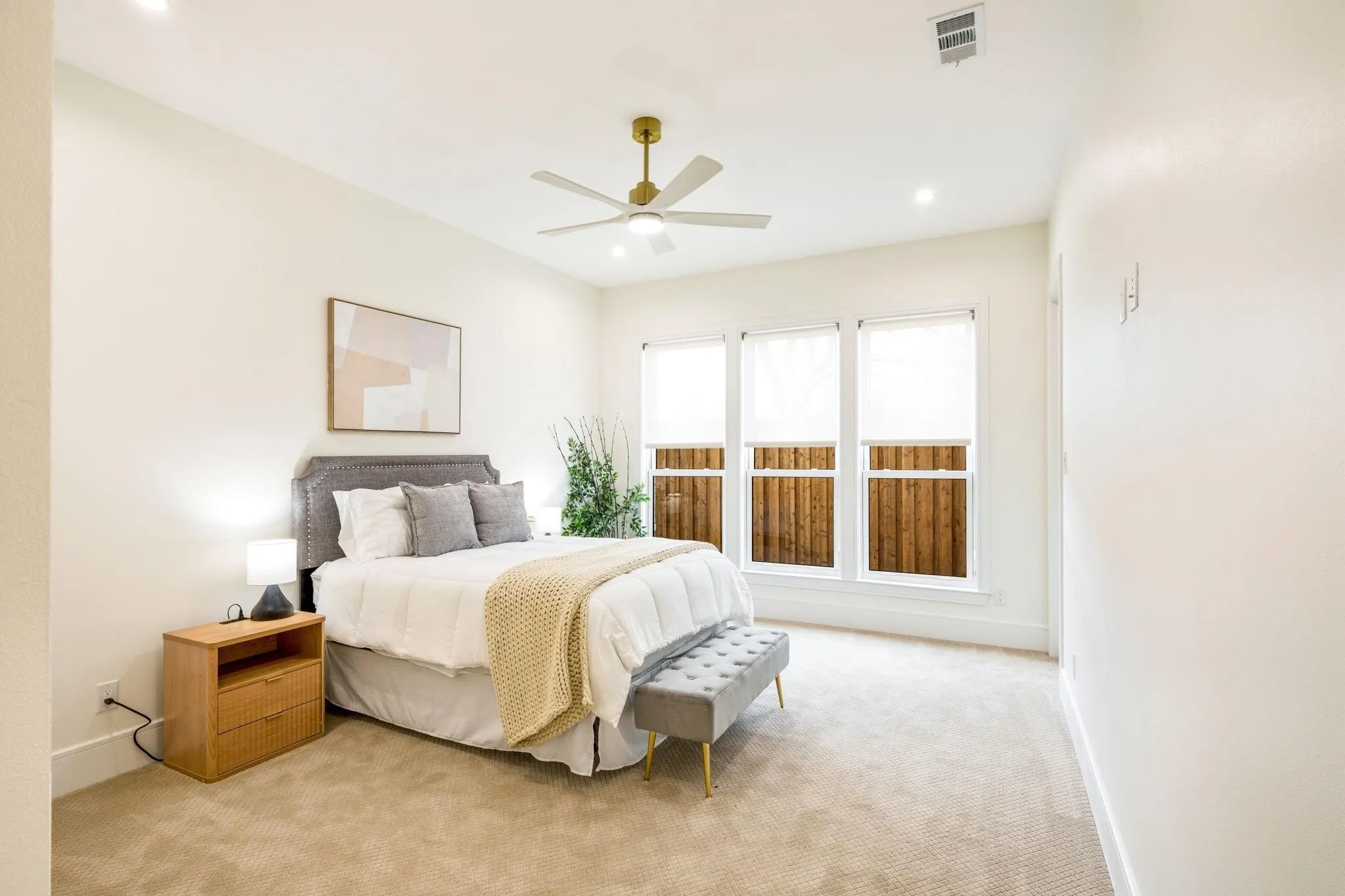 Recessed lighting, ceiling fan with gold-tone hardware, triple windows with privacy blinds, and light-toned carpeting