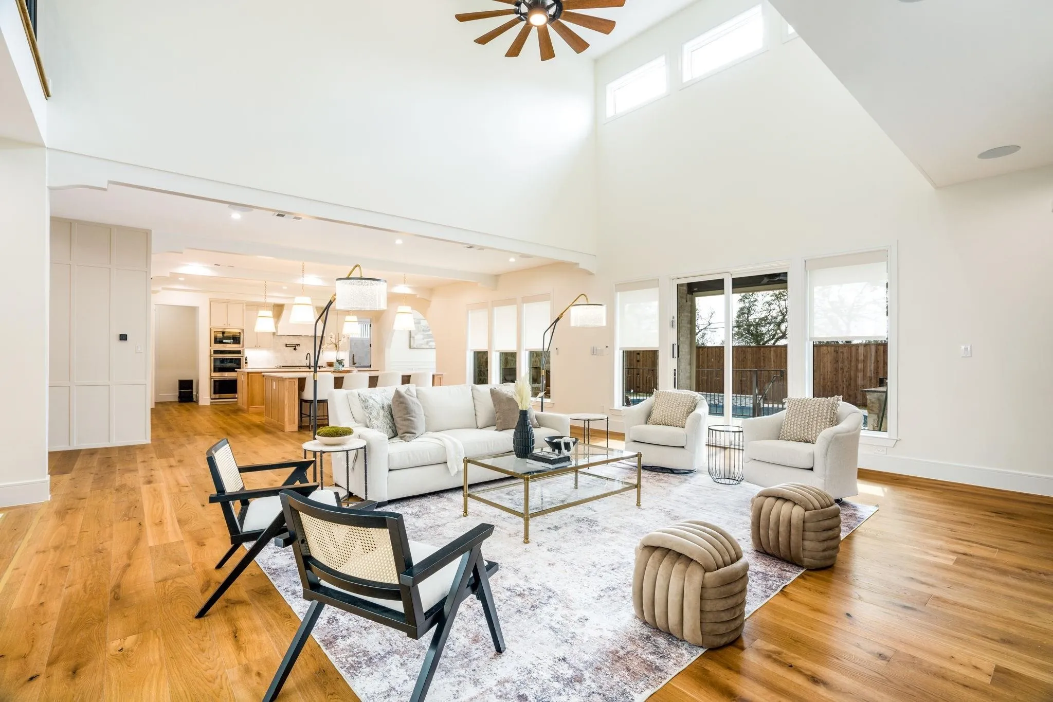Vaulted ceiling with a ceiling fan, wood-finish flooring, sliding glass patio door, built-in kitchen appliances, and recessed lighting