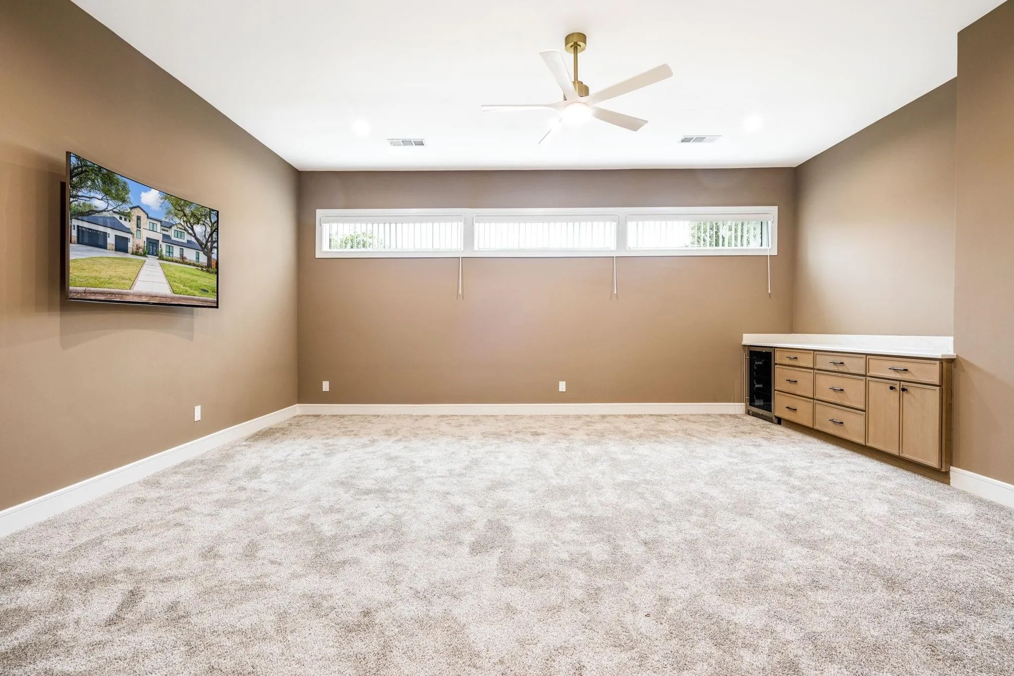 Recessed lighting, ceiling fan, built-in cabinetry, under-counter beverage cooler, and horizontal windows