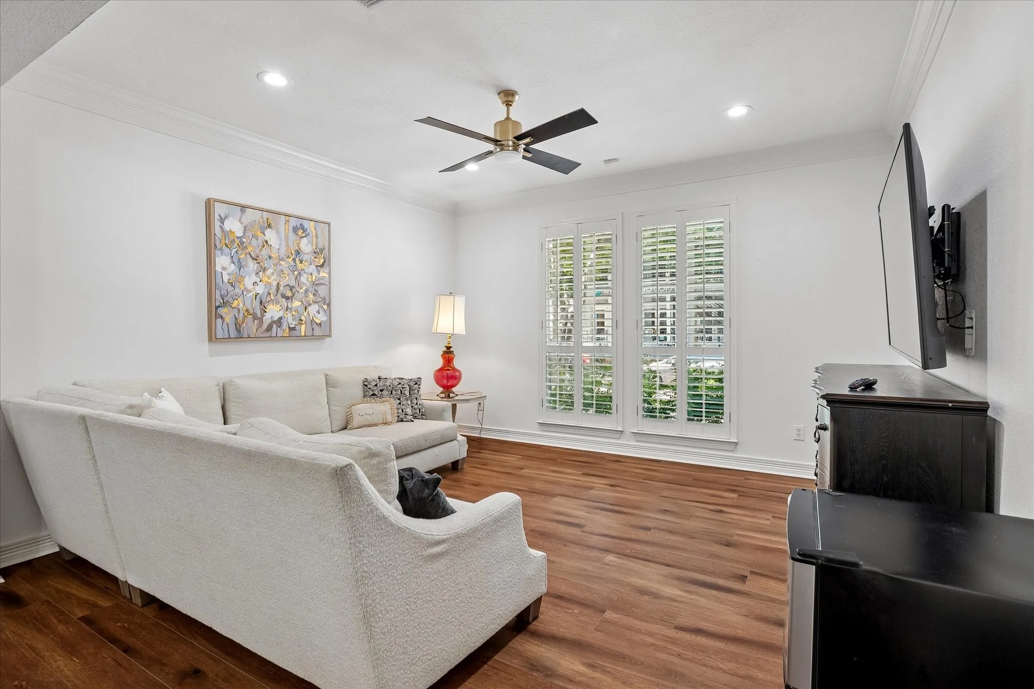 Wood-finish flooring, recessed lighting, and crown molding