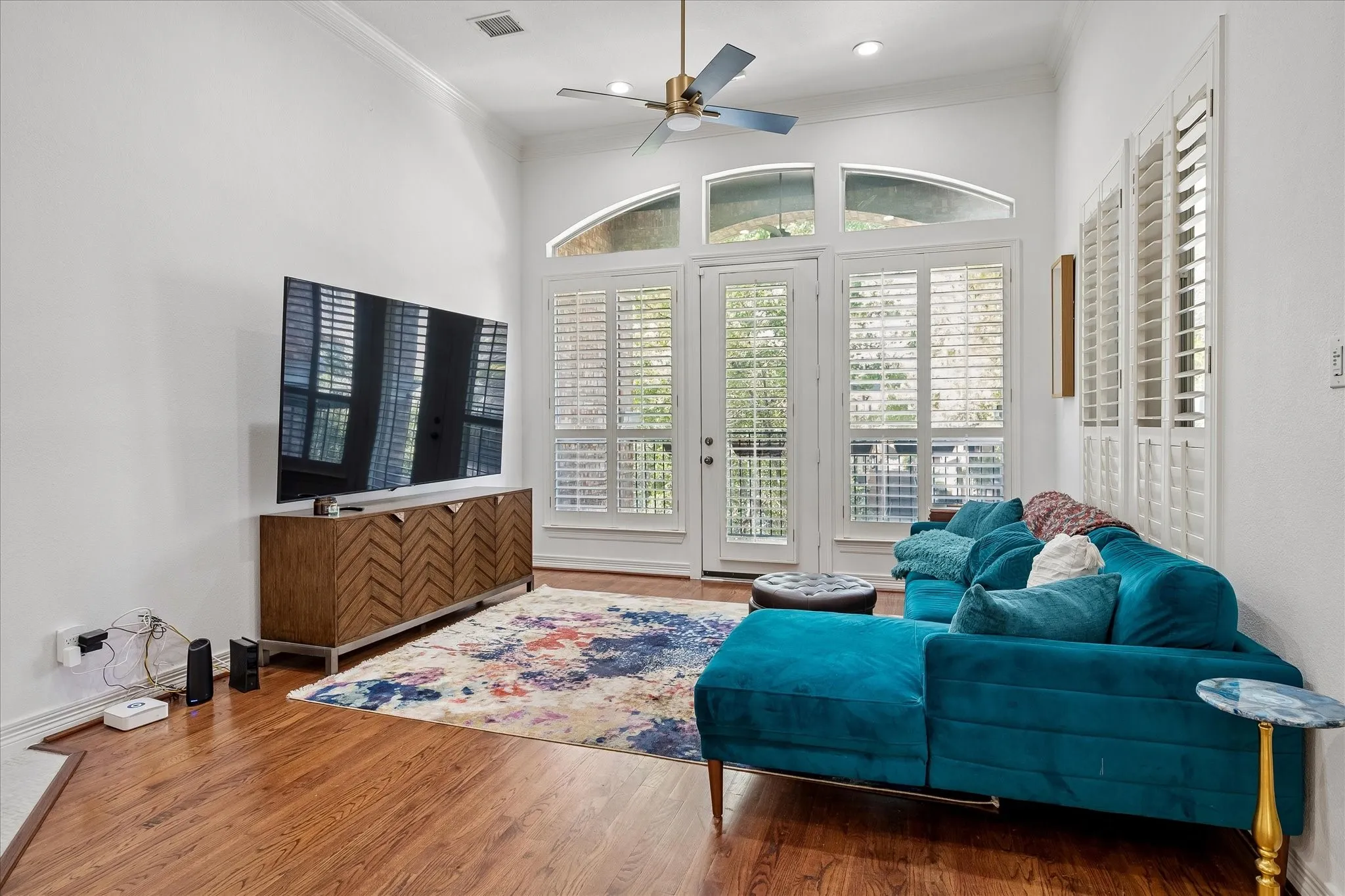 Vaulted ceiling featuring a ceiling fan, recessed lighting, hardwood flooring, and French doors with custom plantation shutters