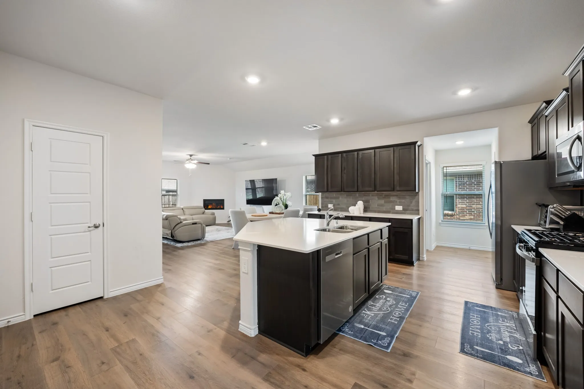 Kitchen featuring dark wood-finish cabinetry, light countertops, and stainless steel appliances