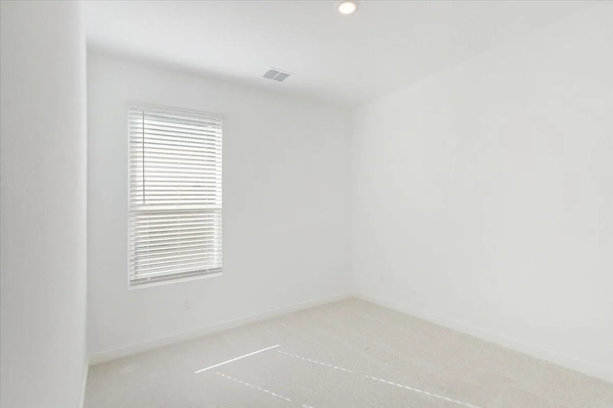 Recessed lighting, window with blinds, light-colored carpeting, white walls