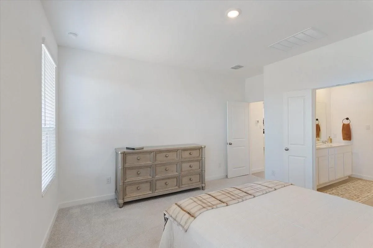 Recessed lighting, plush carpet flooring, and a window with blinds