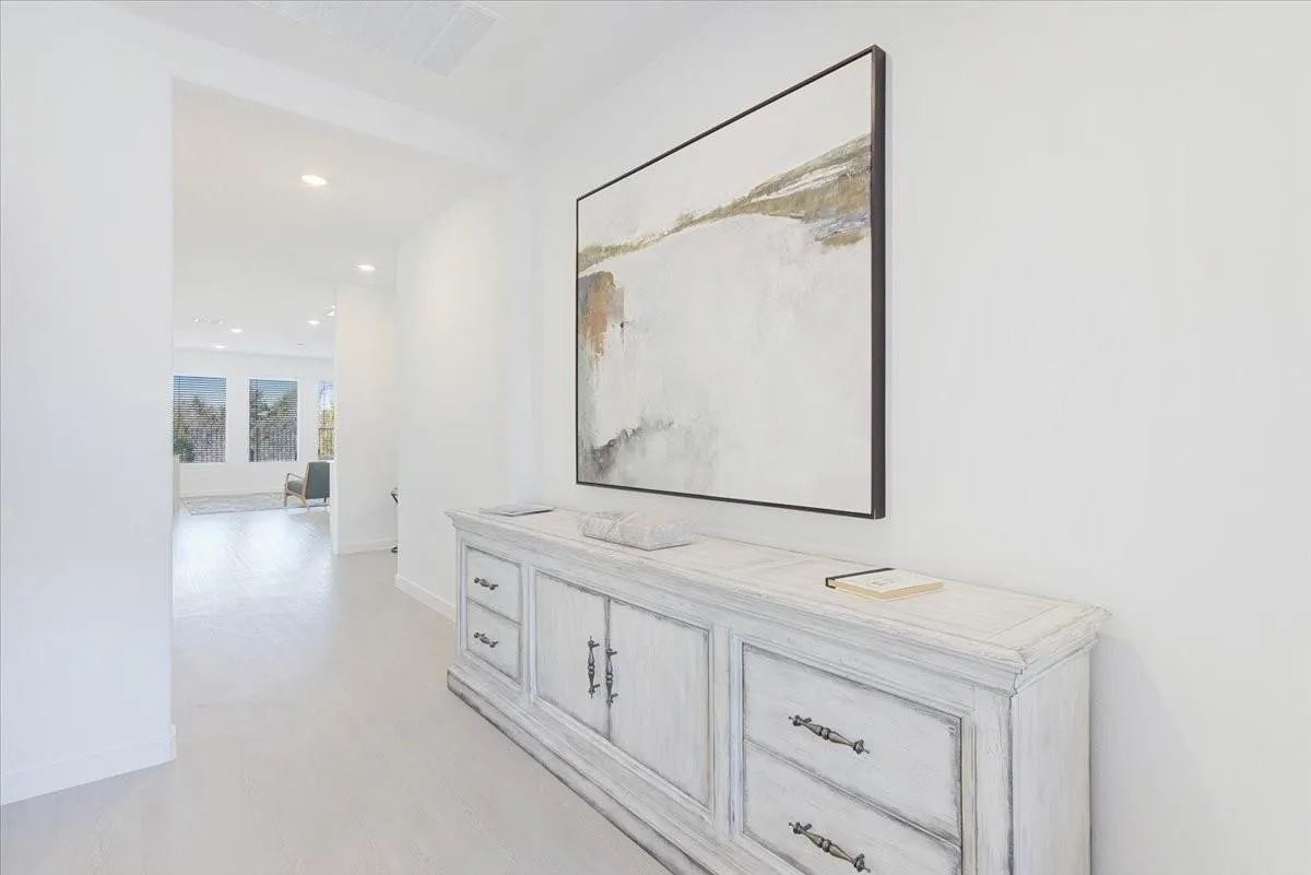 White walls with recessed lighting and light-toned wood-finish flooring