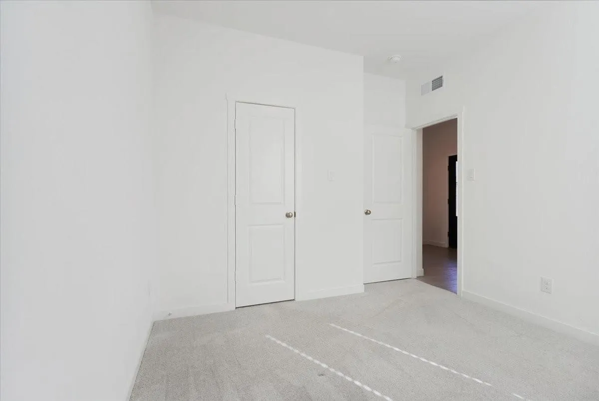Light gray carpeting and white walls with white trim