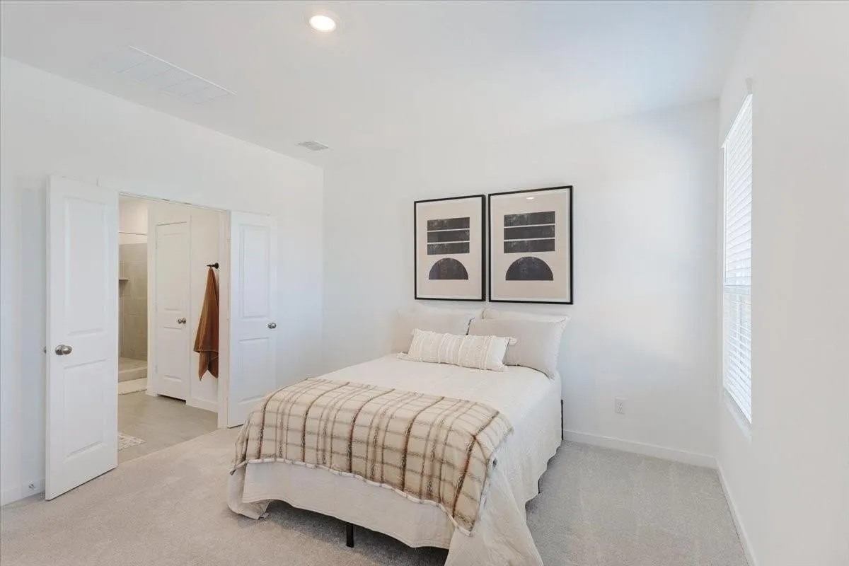 Recessed lighting, light-toned carpeting, and a window with blinds