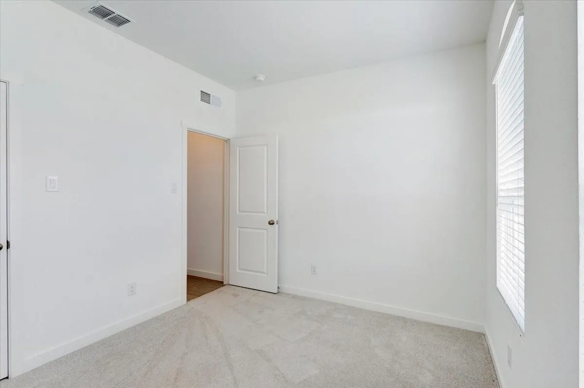 Wall-to-wall carpeting, window with blinds, and white interior doors
