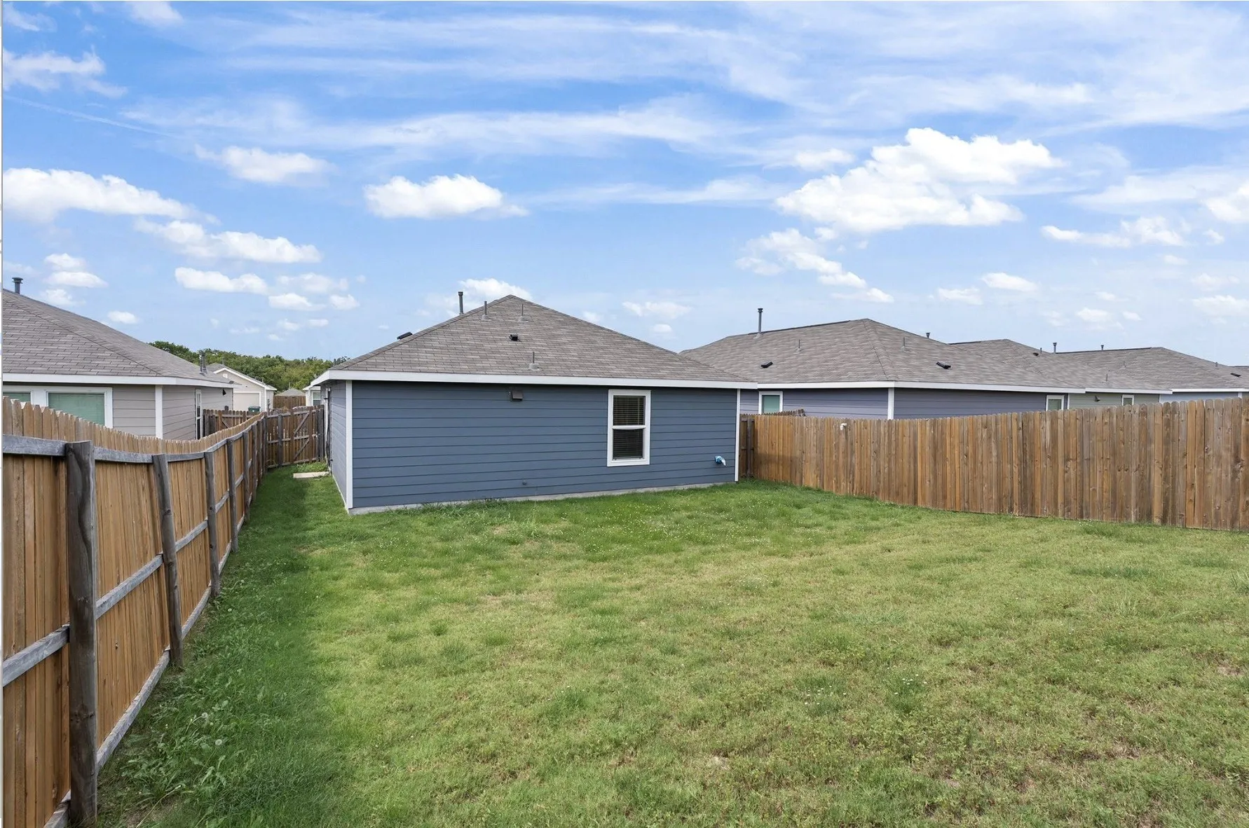 Expansive grass yard with wood fencing