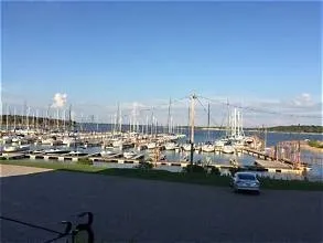 Marina with multiple boat slips, visible body of water, and clear sky
