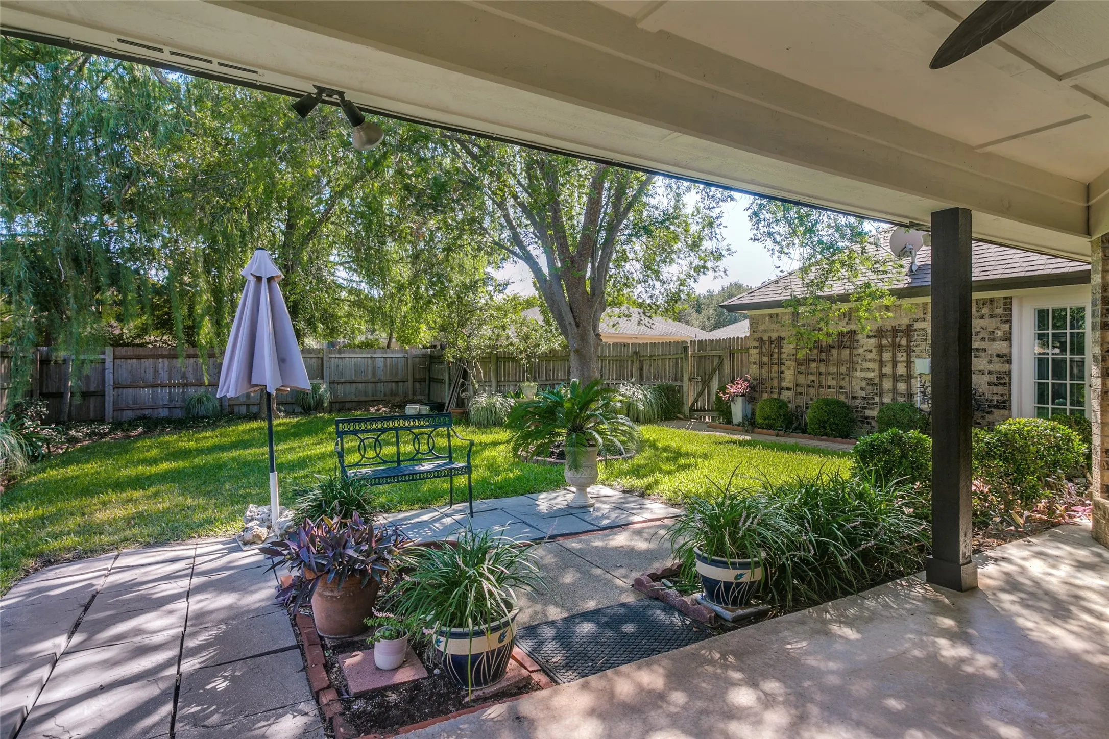 Covered patio with a concrete surface, leading to a flagstone pathway