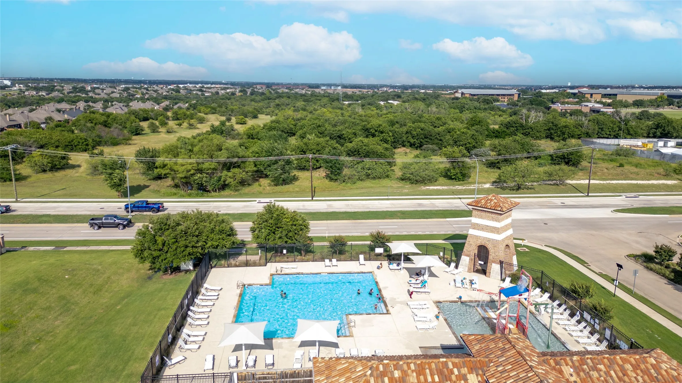 Resort-style pool with multiple swimming areas, a water slide, and a shaded lounge area