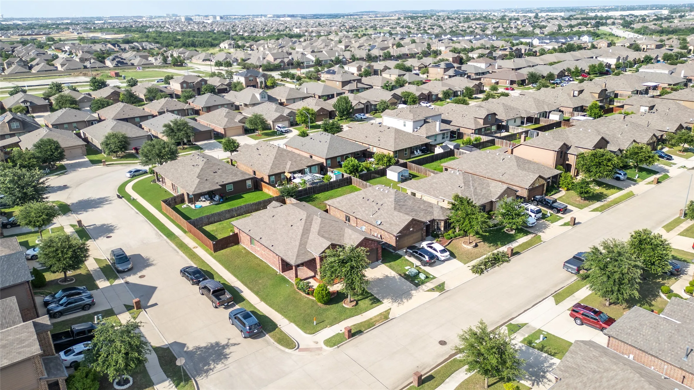 Residential neighborhood featuring a grid of paved streets and numerous single-story homes with shingled roofs