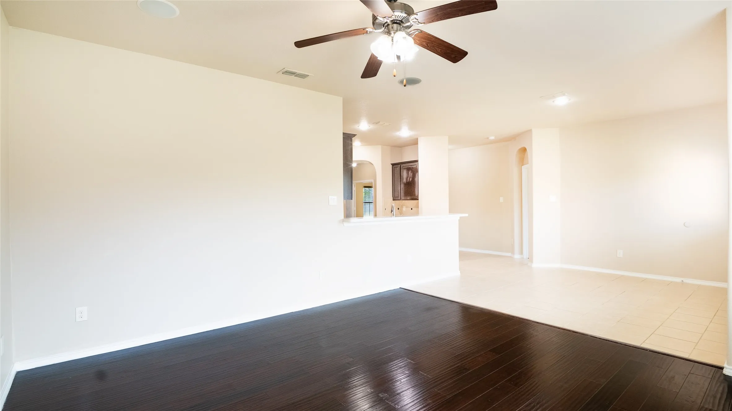 Dark wood-finish flooring, ceiling fan with integrated lighting, recessed lighting, and neutral wall tones
