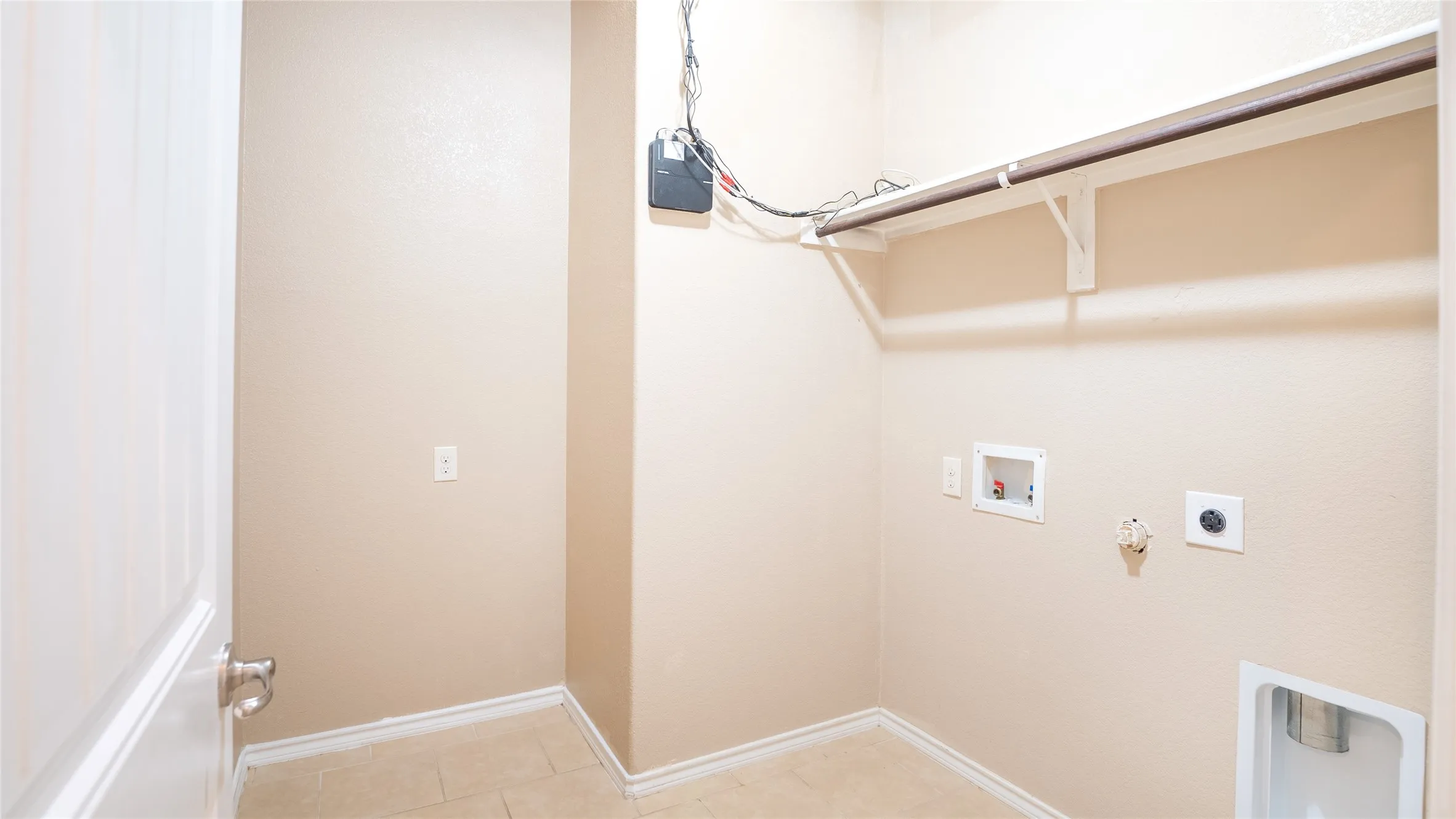 Ceramic tile flooring, neutral wall tones, and a clothes hanging rod with shelving