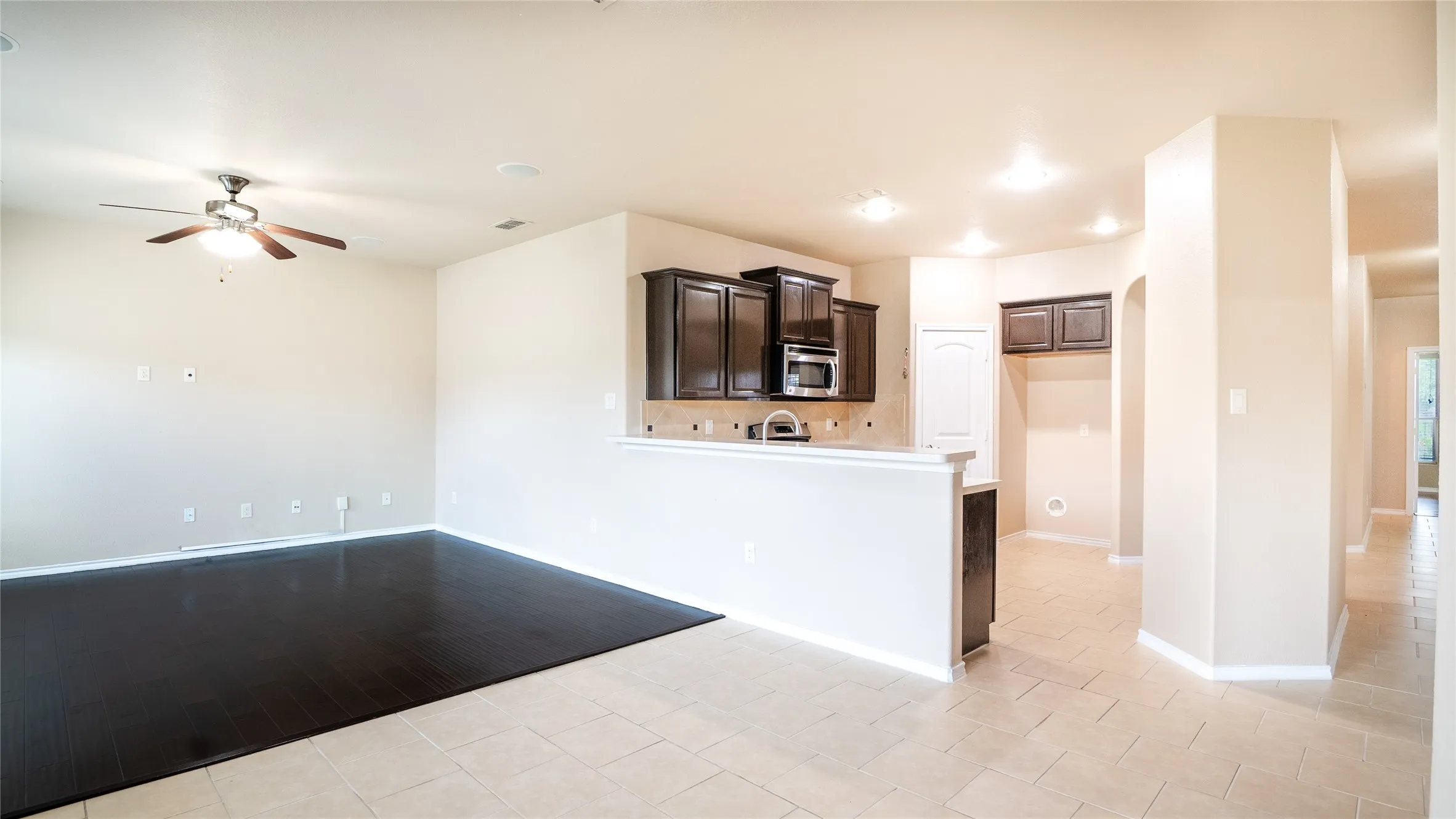 Dark wood-finish flooring, recessed lighting, and a ceiling fan with light fixture