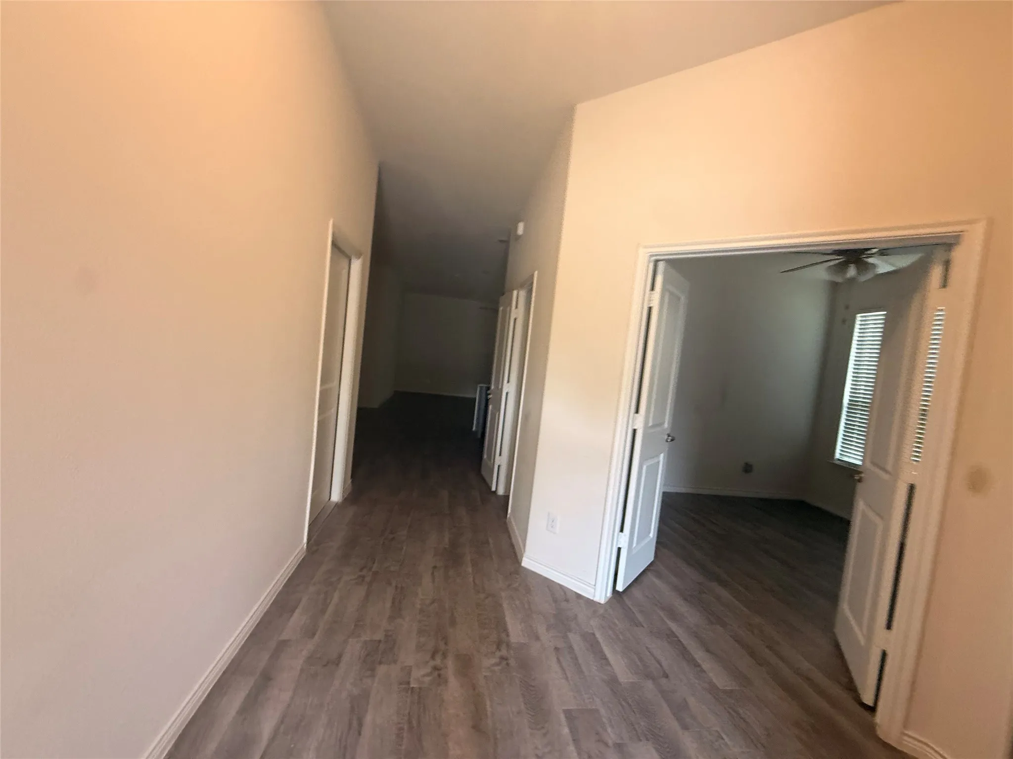 Wood-finish flooring throughout, light neutral wall tones, and recessed lighting