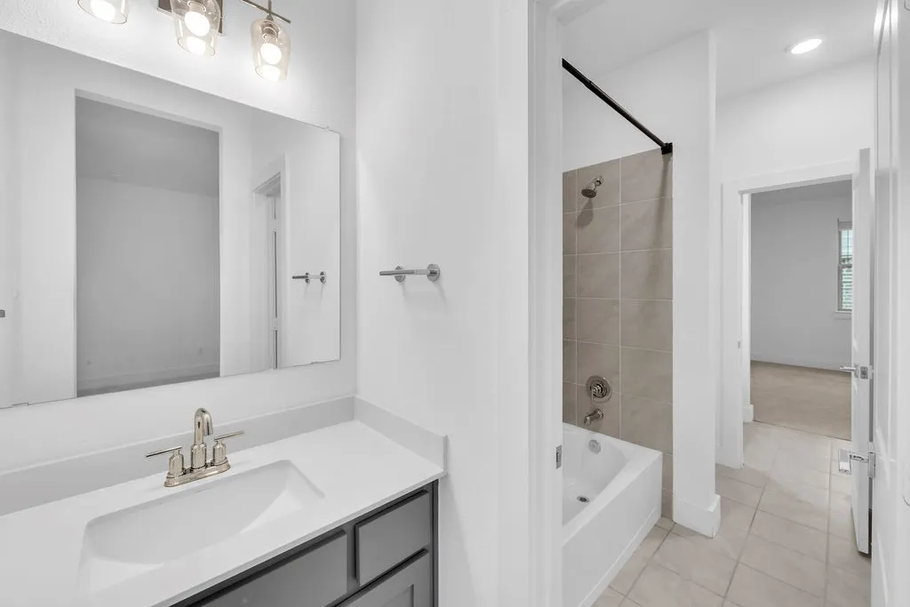 Vanity with a rectangular undermount sink, brushed nickel faucet, and a wall-mounted mirror