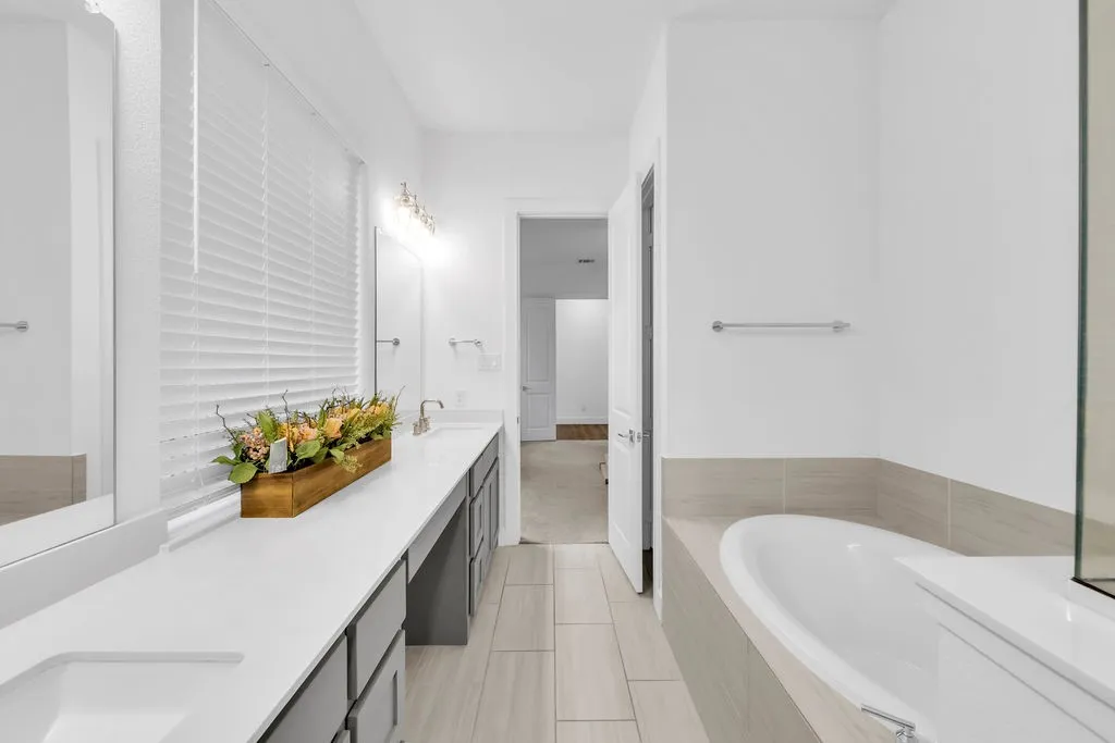 Dual vanity with undermount sinks, white countertops, and gray cabinetry