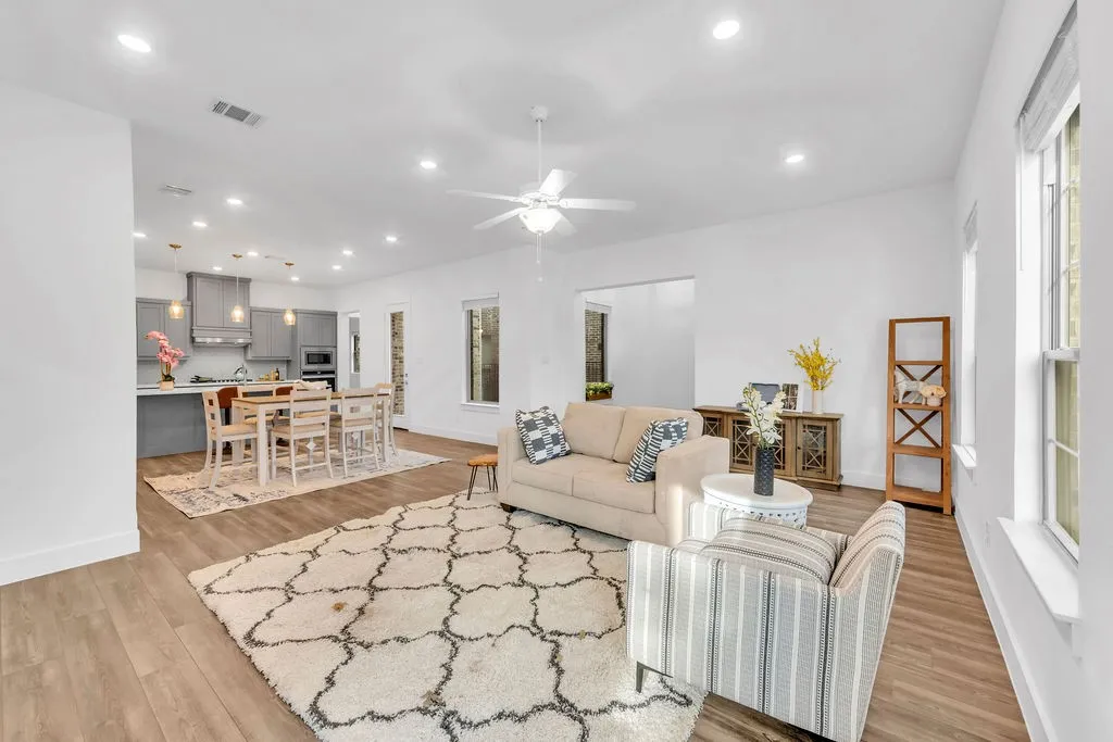Open-concept living space featuring wood-finish flooring, recessed lighting, and a ceiling fan