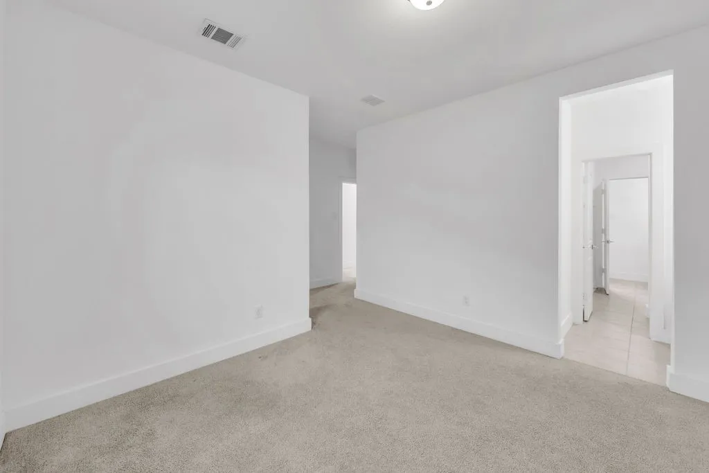 Light-toned carpeting, crisp white walls, and a recessed ceiling light fixture