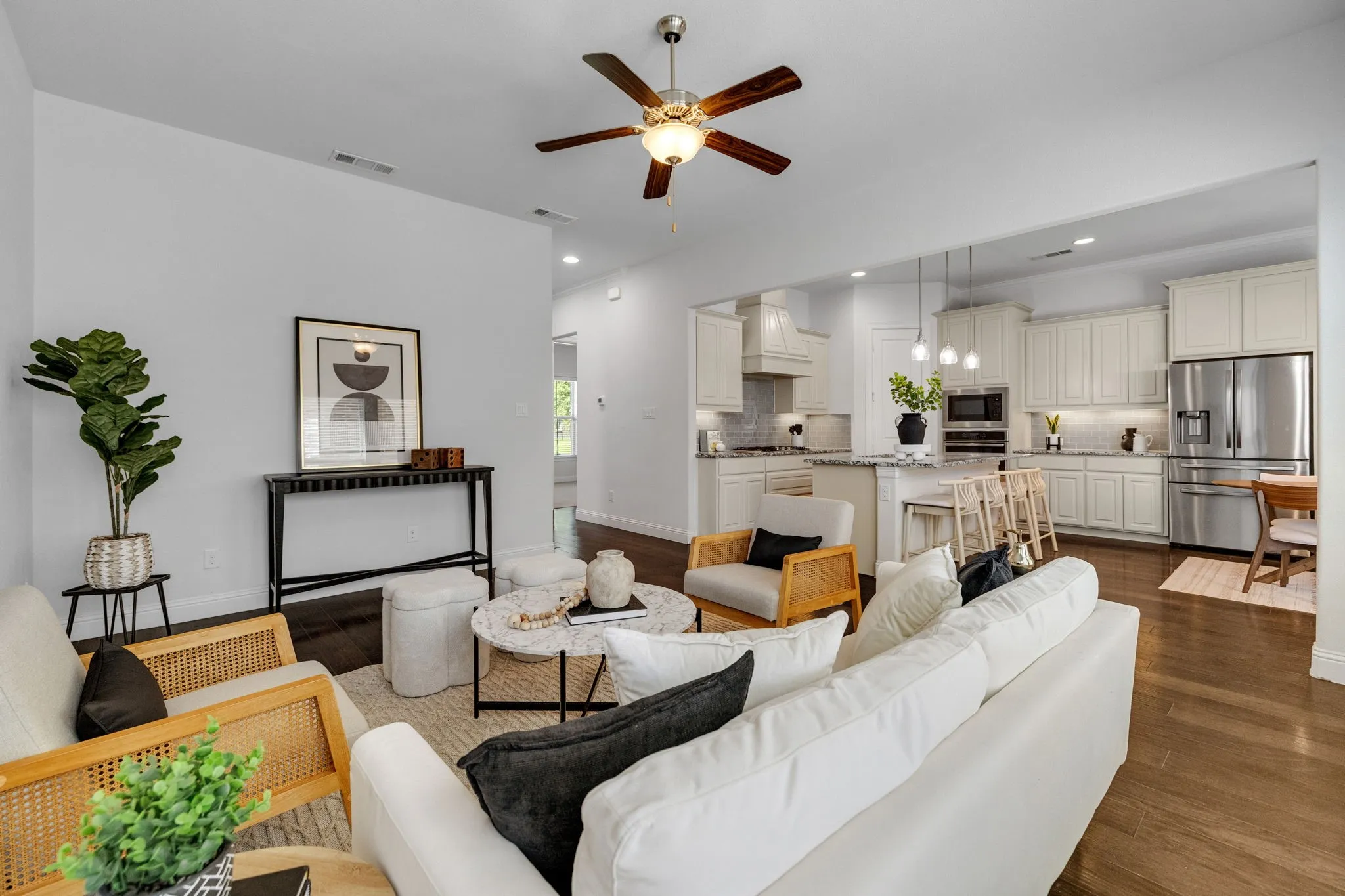 Open-concept living area featuring wood-finish flooring, recessed lighting, and a ceiling fan