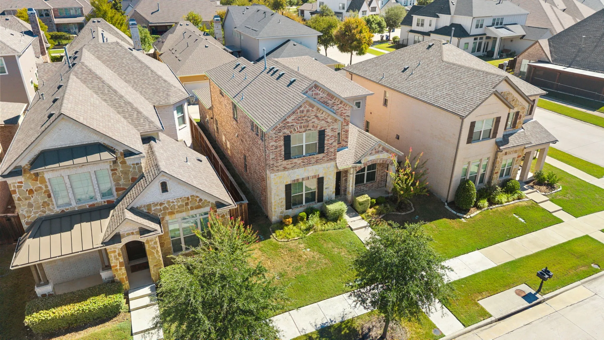Two-story residence featuring a brick and stone facade, multiple gables, and an attached front-facing garage