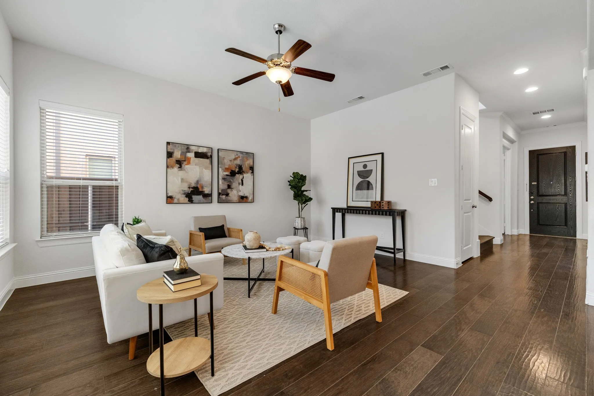 Spacious living area featuring wood-finish flooring, high ceilings, and recessed lighting