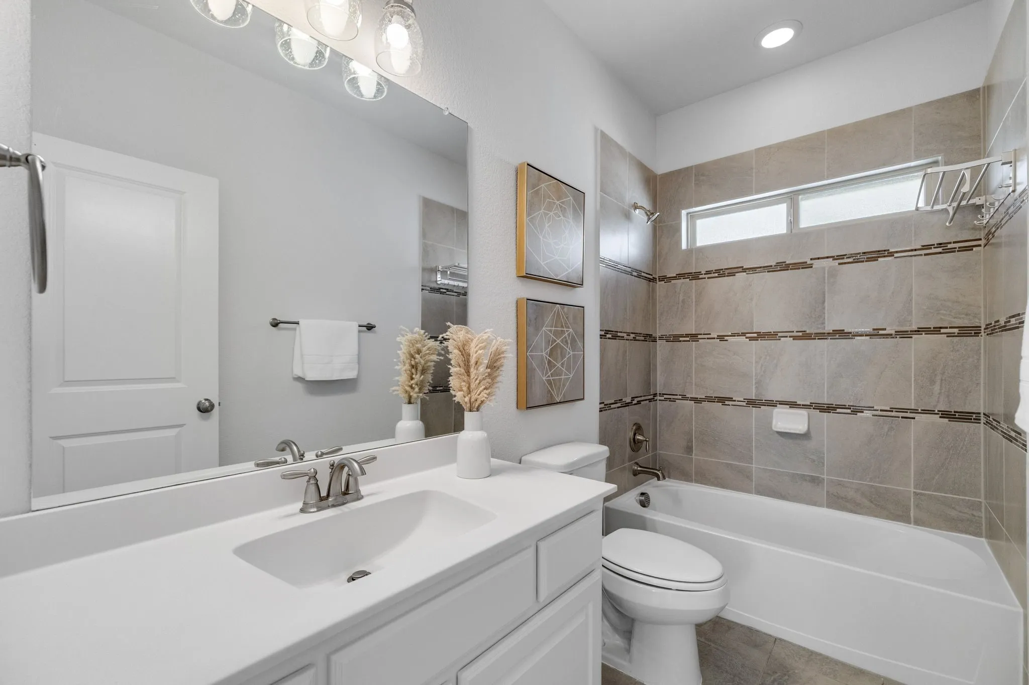 Secondary upstairs bathroom- White vanity with an integrated sink and brushed nickel faucet