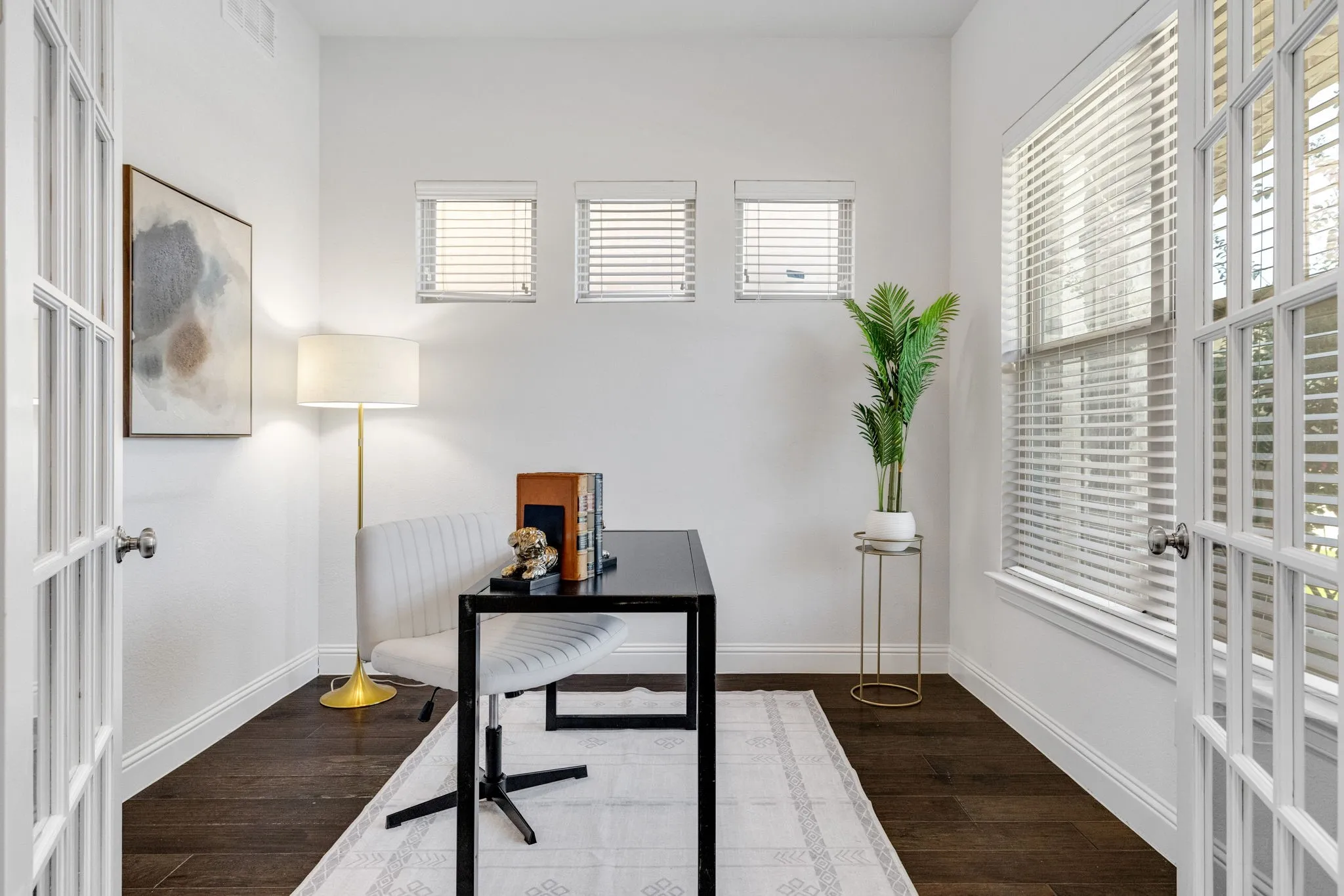 Front office- French doors with glass panes, dark wood-finish flooring, white walls, and multiple windows with blinds