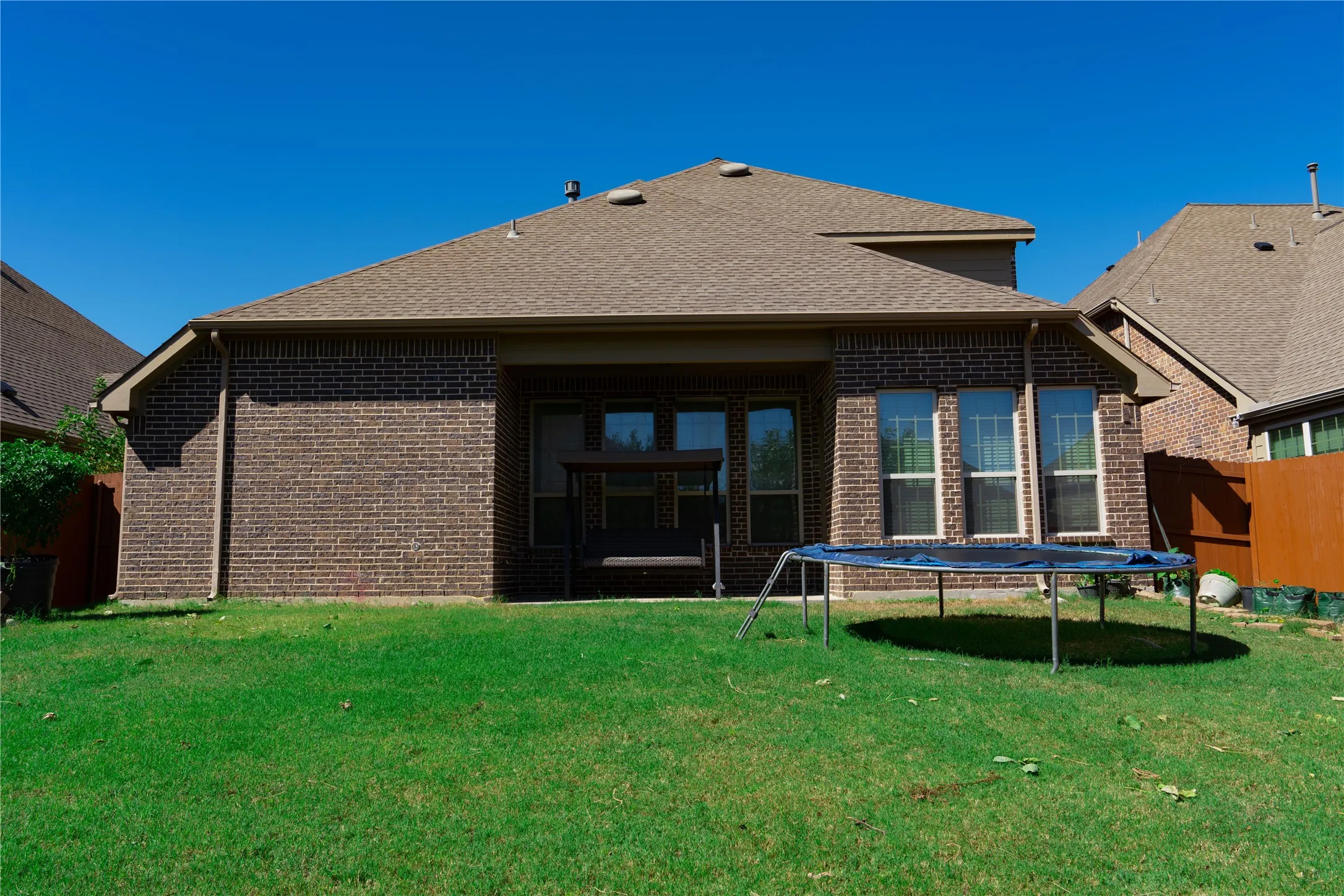Brick exterior with multiple windows and a covered patio