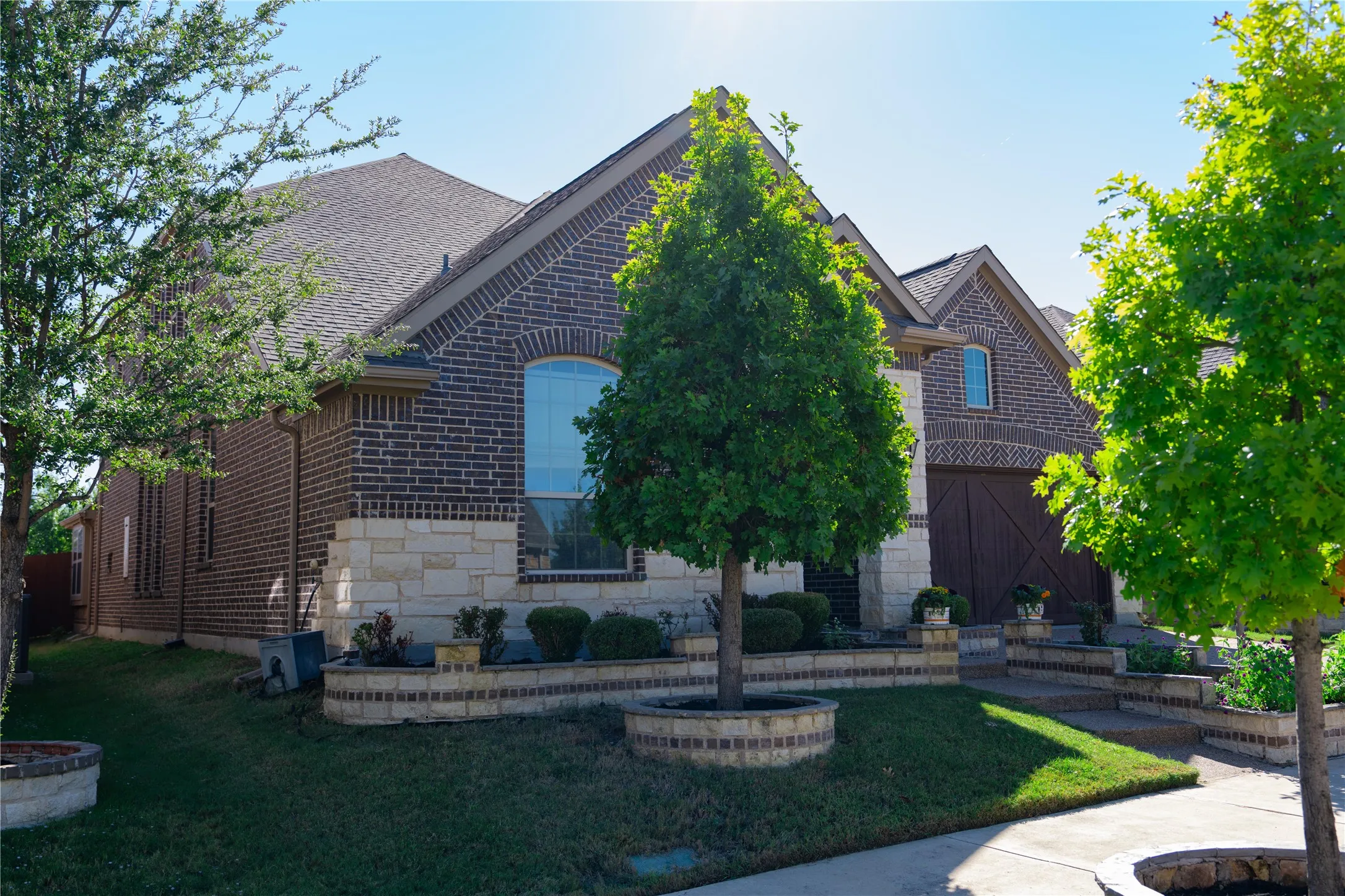 Brick exterior with stone accents, arched windows, and a multi-gabled roofline